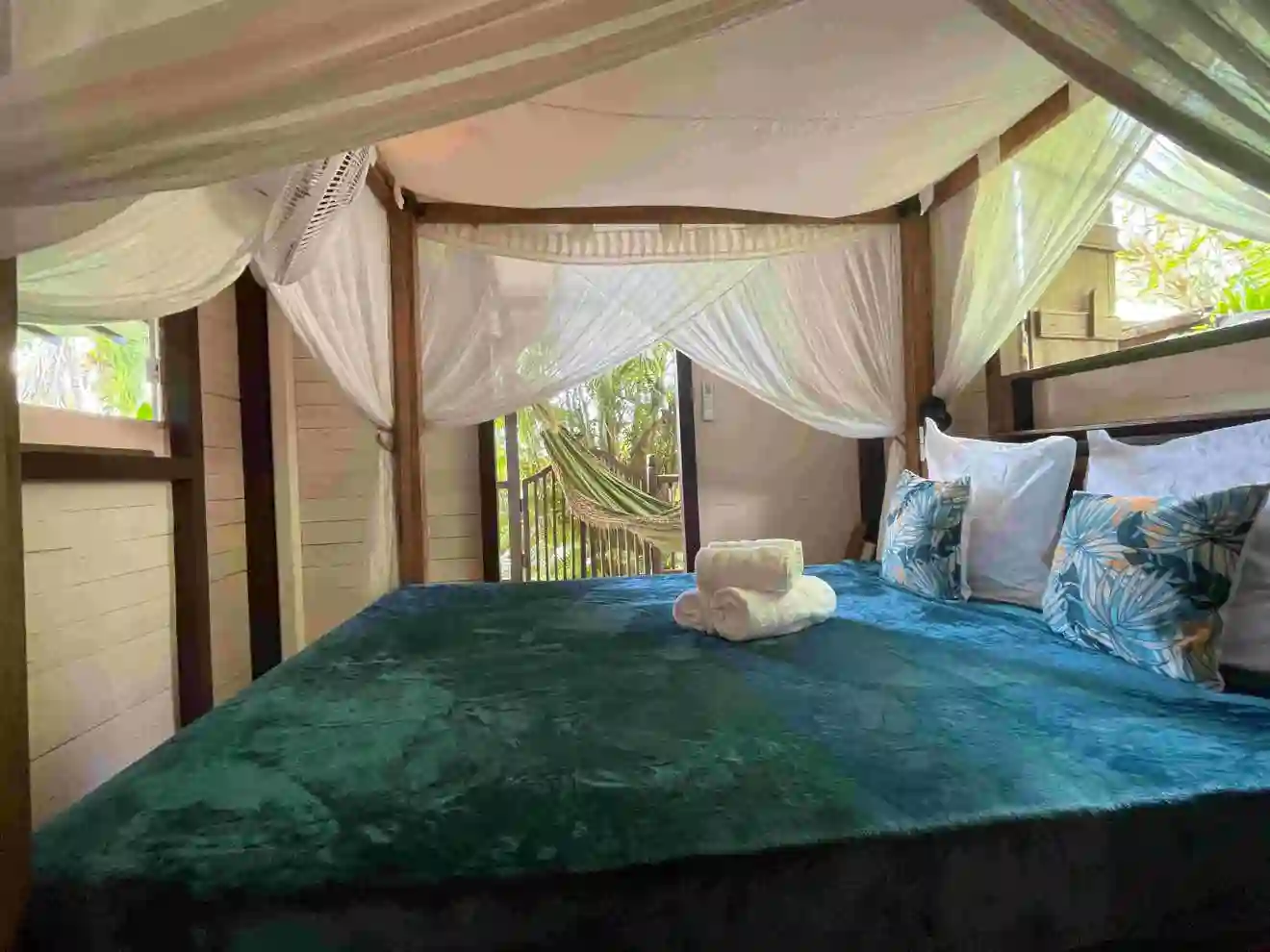 Bedroom with a 160cm queen-size bed, mosquito net, fan, and air conditioning