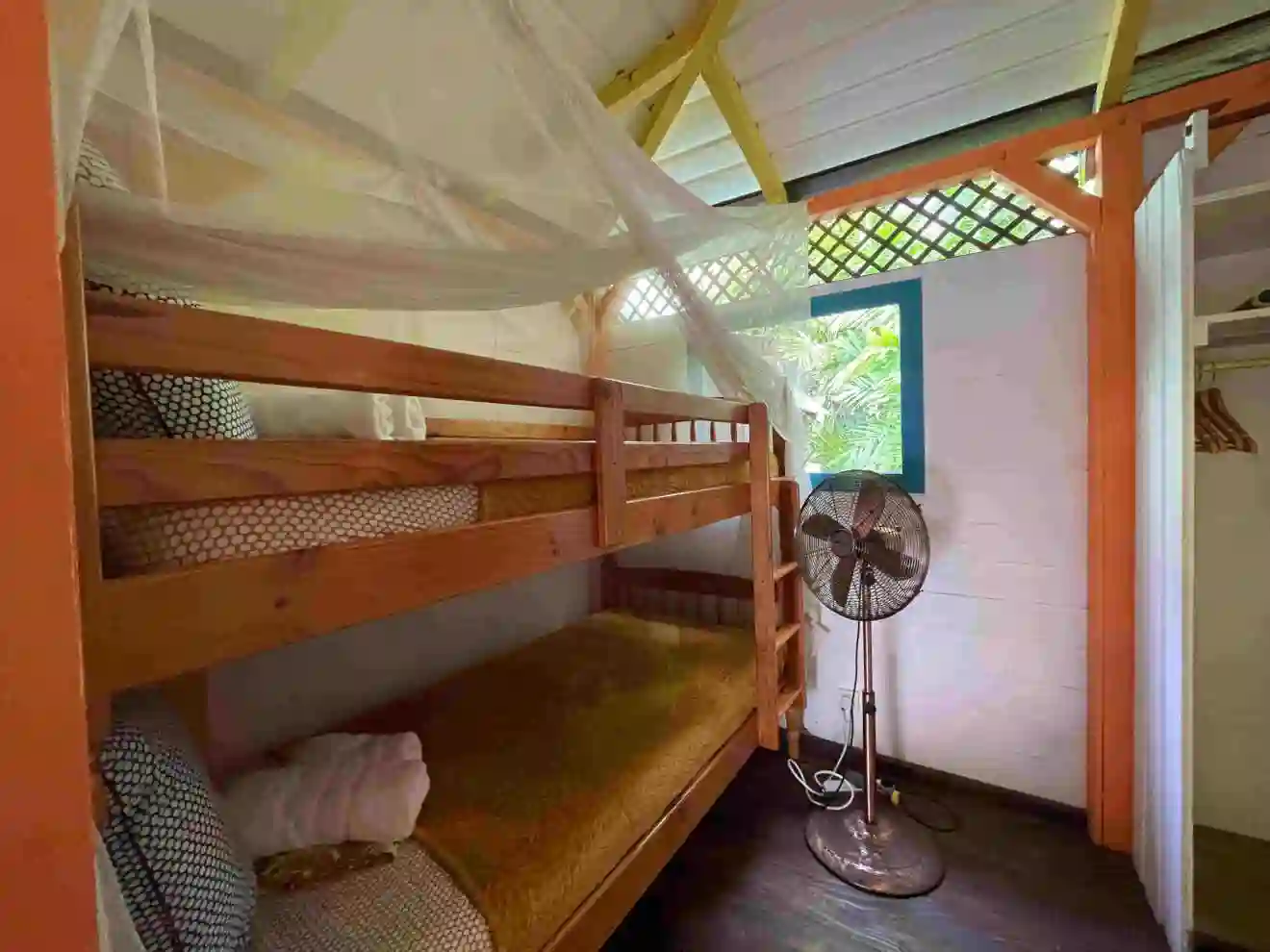 A bedroom for 2 children, bunk beds, with mosquito net and fans